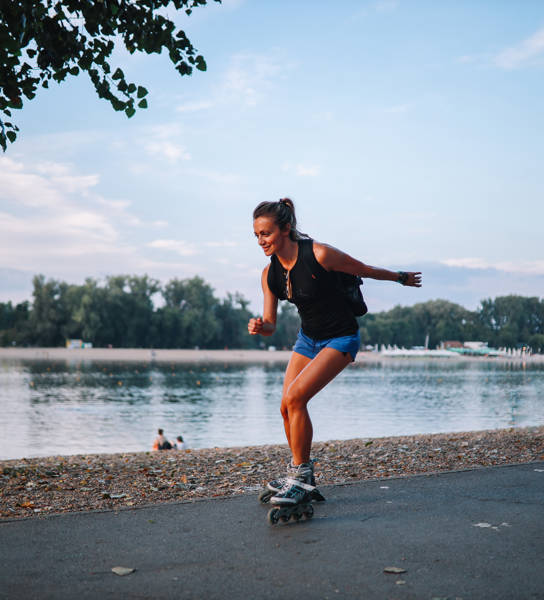 Meisje dat aan het rolschaatsen is op een pad langs het water