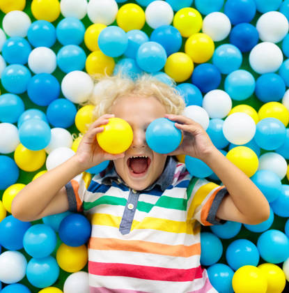 Child playing in ball pit. Colorful toys for kids. Kindergarten or preschool play room. Toddler kid at day care indoor playground. Balls pool for children. Birthday party for active preschooler.
