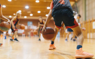 Jonge basketters tijdens training dribbelen met de bal