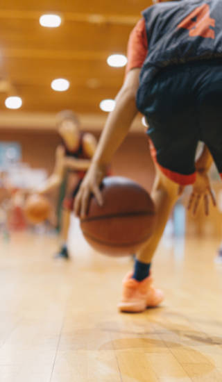 Jonge basketters tijdens training dribbelen met de bal