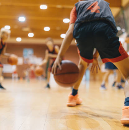Jonge basketters tijdens training dribbelen met de bal