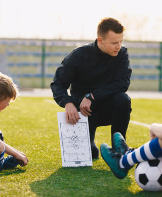 Coach legt tactiek uit aan jonge voetballertjes