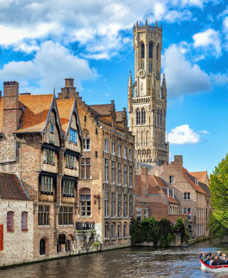 Belgium, Bruges - September 26, 2015: View from the Rozenhoedkaai in Bruges with the Perez de Malvenda house and Belfort van Bruges in the background and number of peoples in the boats.