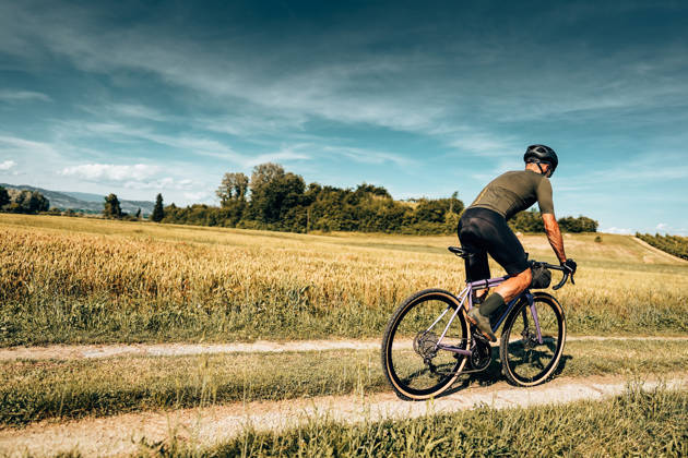 cyclist with gravel bike in italy in the countryside