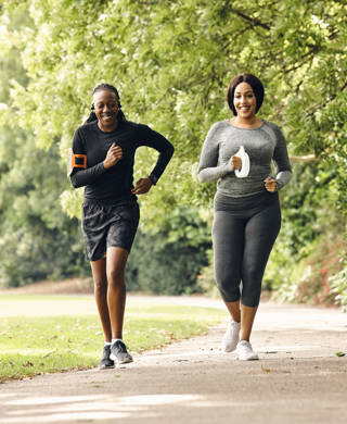 Two healthy women running at morning in the park.