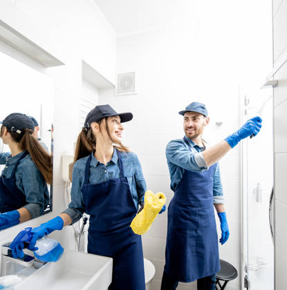 Couple as a professional cleaners in blue uniform cleaning bathroom. Cleaning service concept