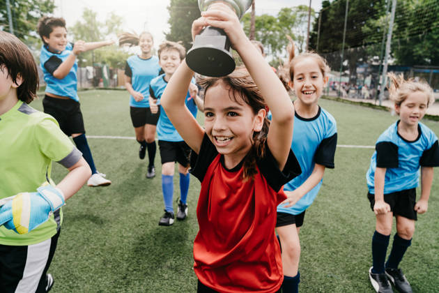 Groepje kinderen viert overwinning met beker